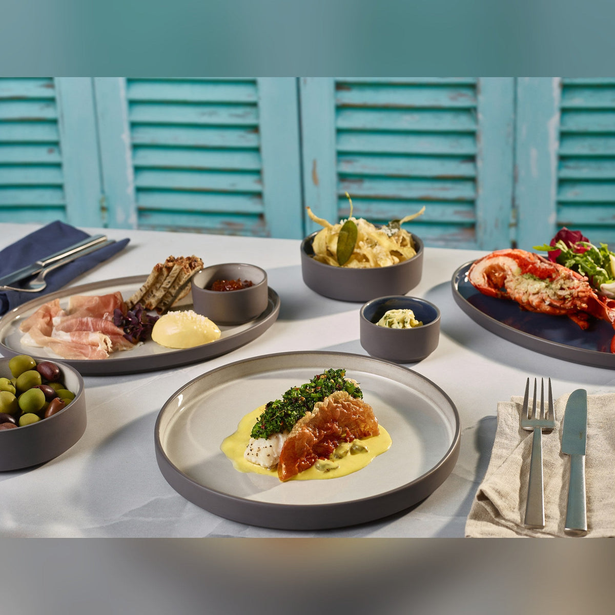 Kava grey porcelain presentation plate 25cm with satin glaze and unglazed wall, lifestyle image