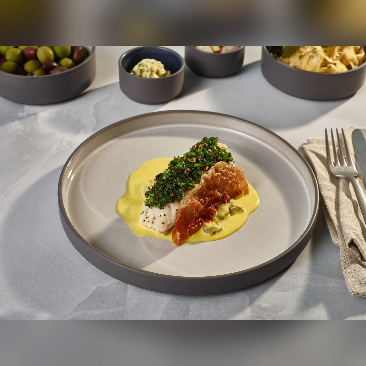 Kava grey porcelain presentation plate 25cm with satin glaze and unglazed wall, lifestyle image