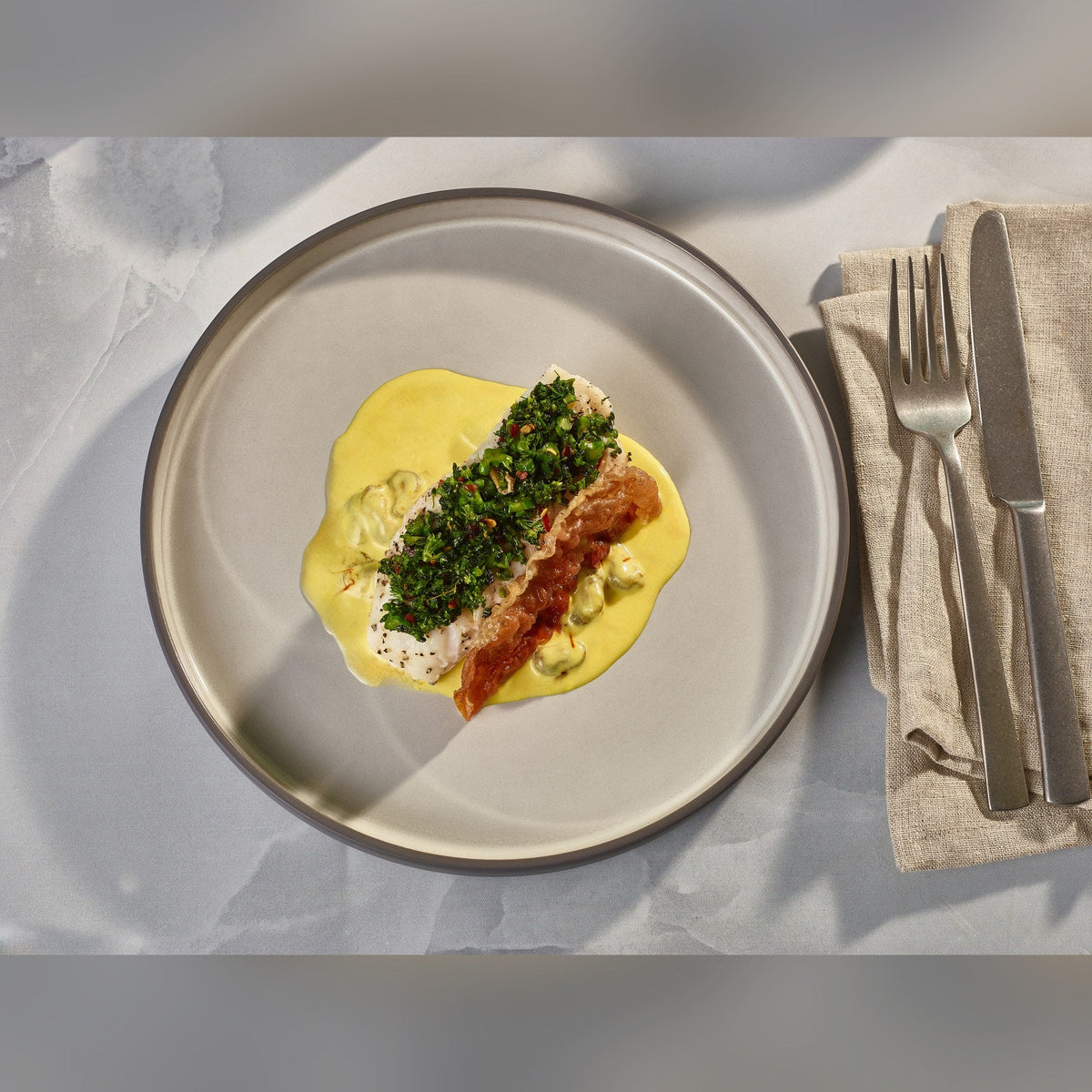 Kava grey porcelain presentation plate 25cm with satin glaze and unglazed wall, lifestyle image