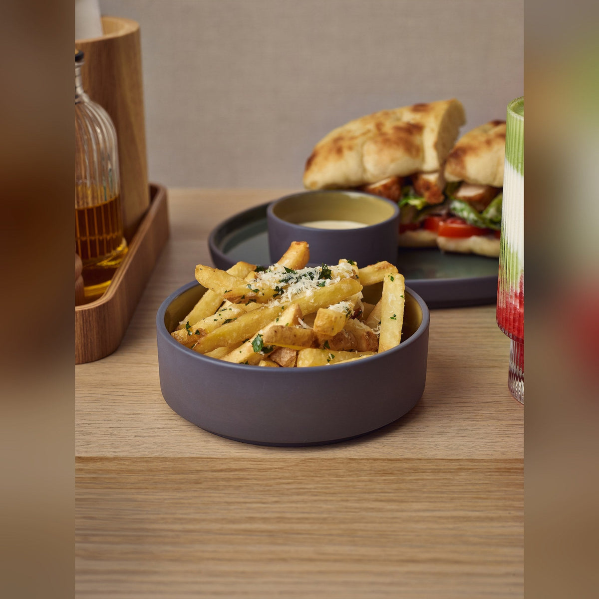 Kava yellow porcelain presentation bowl 13cm with unglazed grey wall, lifestyle image