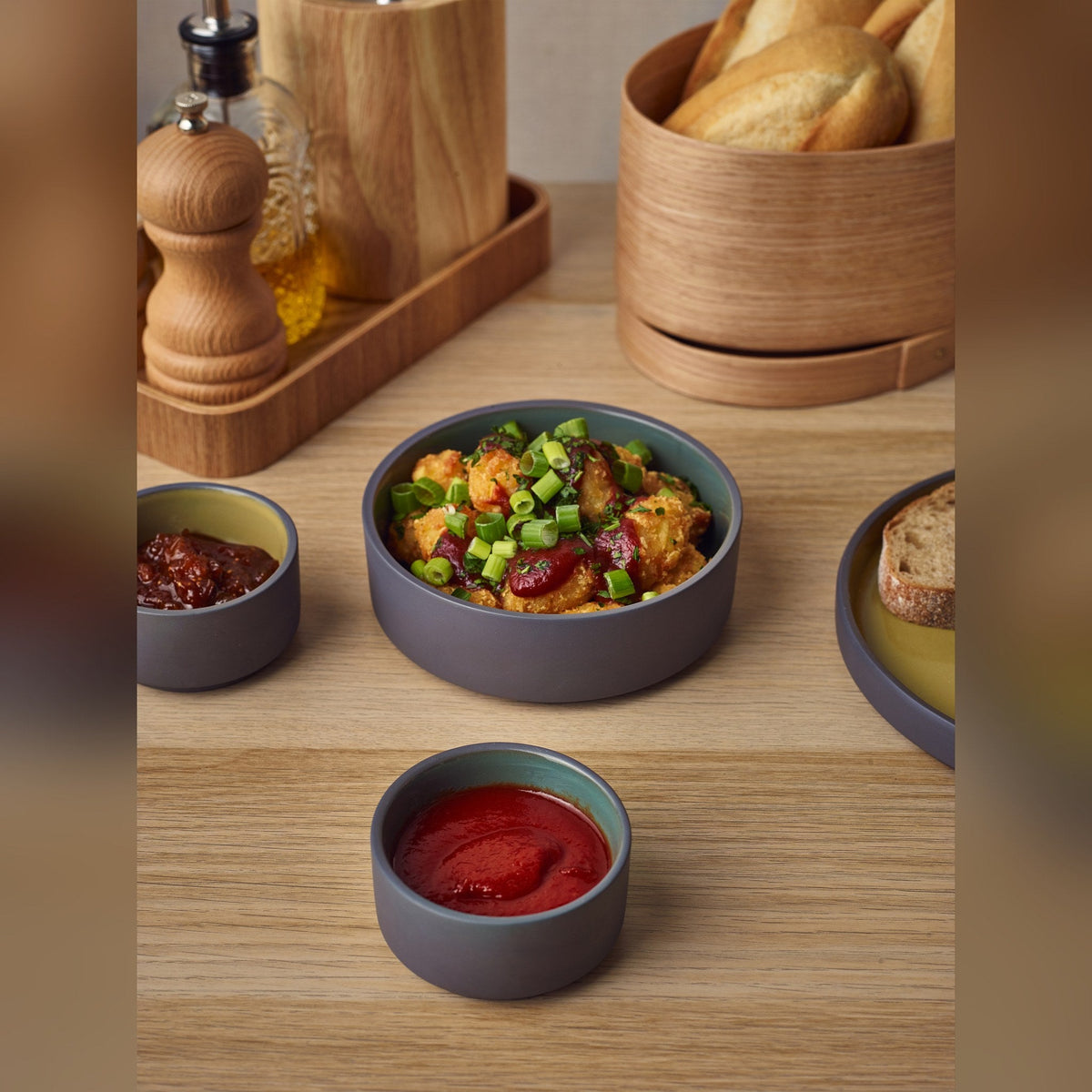 Kava green satin glaze porcelain ramekin 7.5cl with exposed grey wall, lifestyle image