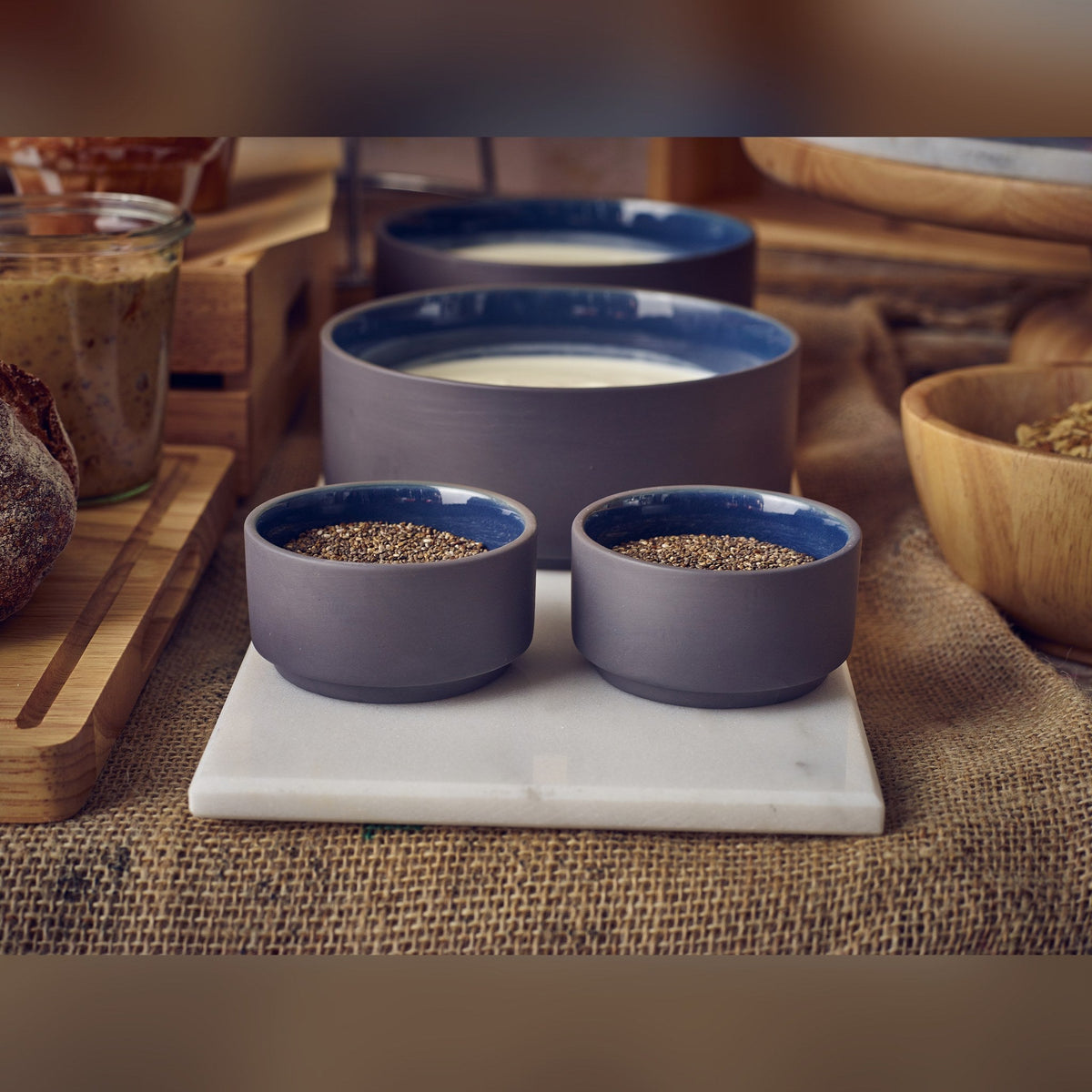 Kava blue satin glaze porcelain ramekin 7.5cl with exposed grey wall, lifestyle image