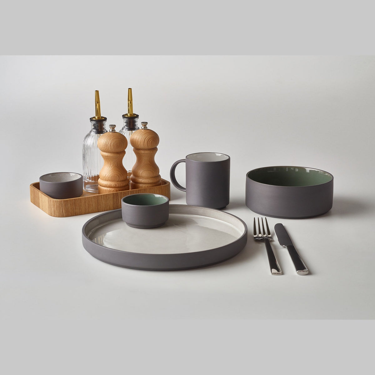 Kava green satin glaze porcelain ramekin 7.5cl with exposed grey wall, lifestyle image
