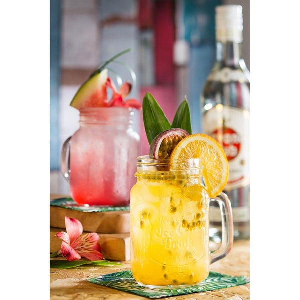 Two Utopia Alabama Handled Drinks Jars filled with refreshing watermelon and pineapple cocktails, beautifully presented with hibiscus garnish.